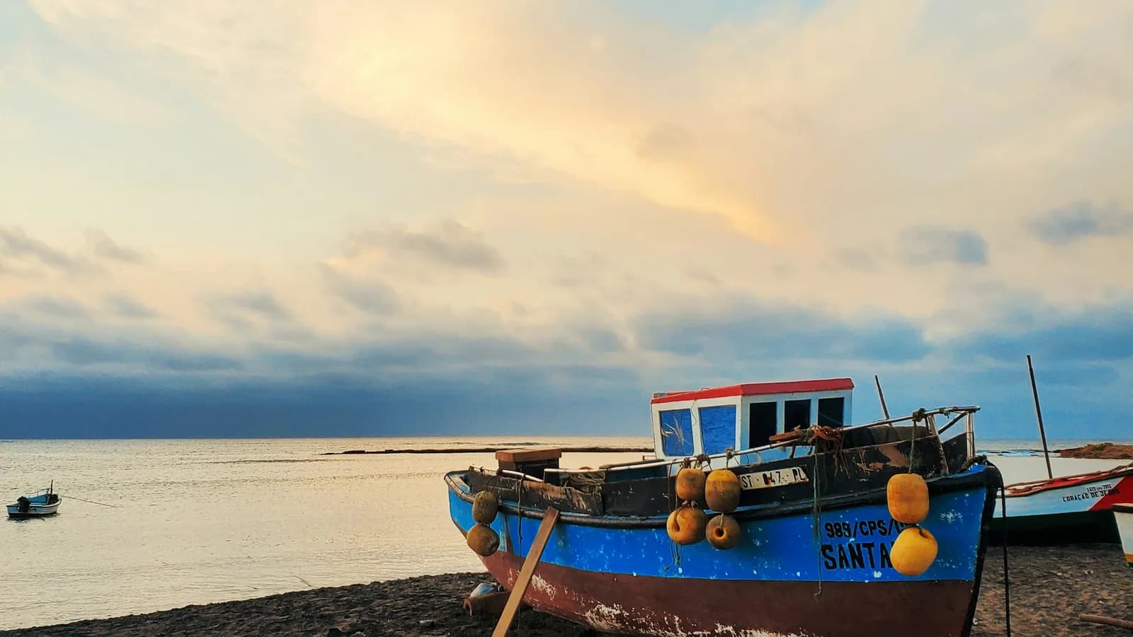 Hölzernes Fischerboot am Strand im Abendlicht