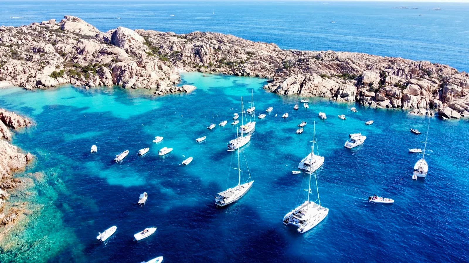 Segelyachten ankern in einer türkisen Bucht im La-Maddalena-Archipel