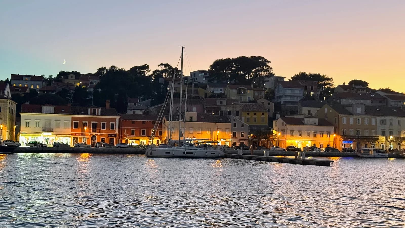 Hafen von Mali Lošinj in der Dämmerung, Segelyacht an der Stadtmole